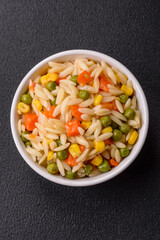 Delicious boiled rice with vegetables corn, carrots, peas with salt