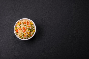 Delicious boiled rice with vegetables corn, carrots, peas with salt