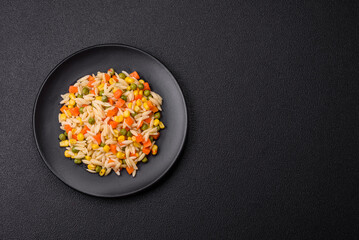 Delicious boiled rice with vegetables corn, carrots, peas with salt