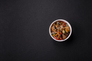 Spicy Asian dish with sliced meat fillet, hot pepper, carrots and sesame seeds