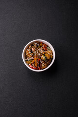 Spicy Asian dish with sliced meat fillet, hot pepper, carrots and sesame seeds