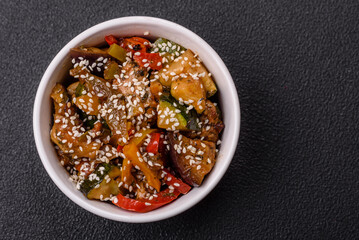 Spicy Asian dish with sliced meat fillet, hot pepper, carrots and sesame seeds