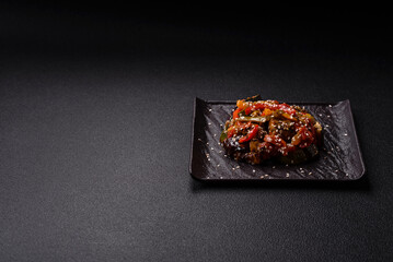 Spicy Asian dish with sliced meat fillet, hot pepper, carrots and sesame seeds