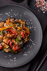 Spicy Asian dish with sliced meat fillet, hot pepper, carrots and sesame seeds
