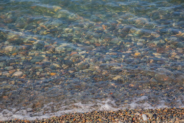 Waves on the beach. Clear sea water. Stone sea beach.