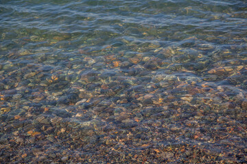 Stones on the beach. Clear water in the sea.