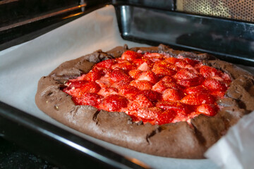 The process of baking a galette with strawberries in the oven.