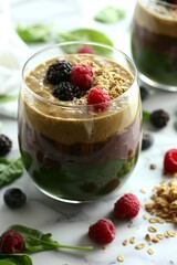 Layered Smoothie: A healthy fresh layered smoothie in a glass, with layers of berry, mango, topped with granola and fresh fruit. Vitamins, fitness drink, health food.