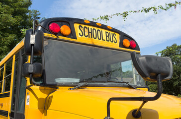 Shot of retro-styled yellow school bus with extended red stop sign standing still on serene road, empty vehicle with no driver awaiting children to boarding, transportation concept, copy space