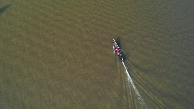 Drone flying around a Kolae boat on the coast of Surat Thani, sunrise in Thailand