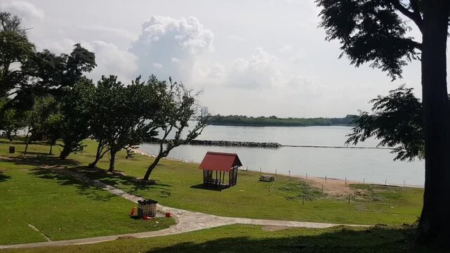 sunny sea view with small pavilion , trees and clouds and in a tropical island. St John island in singapore