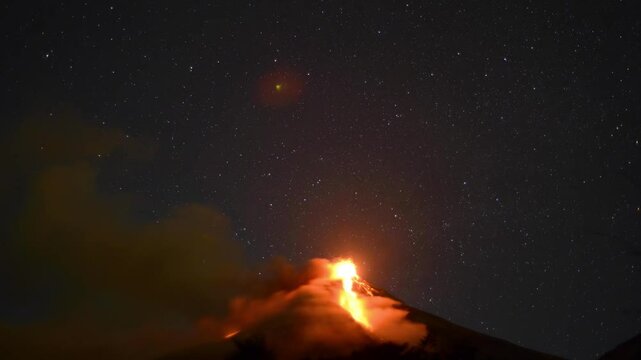 Fuego volcano in Antigua Guatemala erupting at night with the stars moving in the background