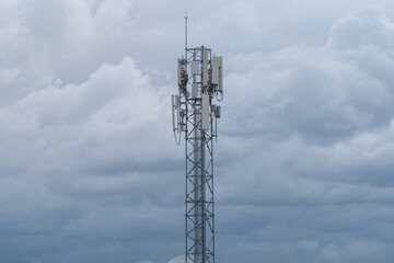 Telephone signal tower with a background of blue clouds.