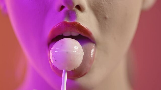 girl licking popsicle with seduction, mouth close-up shot on red background
