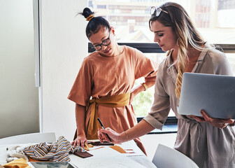 Designer, women and laptop in studio for fashion or trend research, digital design and sketching with fabric for tailor. Business, team and tech for brainstorming, planning and prototype development.