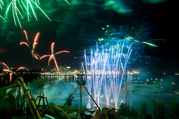Holiday fireworks above water with reflection on the black sky background