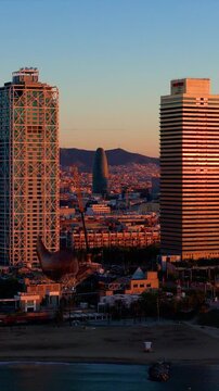 Aerial vertical of Torre Mapfre Skyscraper with Barcelona skyline at sunset time in Spain, Catalunya