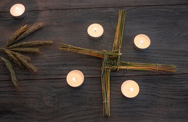Wiccan altar for Imbolc sabbath. religion winter-spring pagan festive ritual. Brigid's cross, candle, wheel of the year on wooden table. symbol of Imbolc holiday, spring equinox. 2025