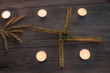 Wiccan altar for Imbolc sabbath. religion winter-spring pagan festive ritual. Brigid's cross, candle, wheel of the year on wooden table. symbol of Imbolc holiday, spring equinox. 2025