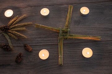 Wiccan altar for Imbolc sabbath. religion winter-spring pagan festive ritual. Brigid's cross, candle, wheel of the year on wooden table. symbol of Imbolc holiday, spring equinox. 2025