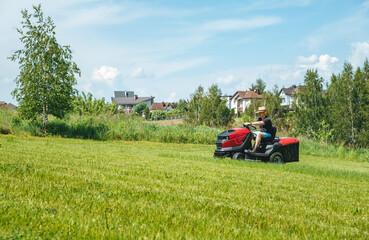 Man on lawn tractor mowing lawn on backyard. The red rider. The lawnmower tractor. High quality 4k footage