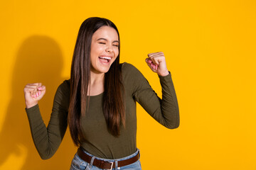 Photo portrait of attractive teen woman raise fists winning dressed stylish khaki clothes isolated...