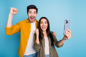 Photo of lucky good mood lady guy wear shirt winning game modern gadget emtpy space isolated blue color background