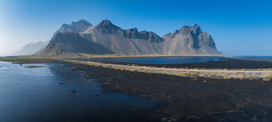 Stunning moody aerial landscape of mountain in Iceland. Impressive Colorful Seascape of Iceland. Wonderful picturesque Scene near Stokksnes cape and Vestrahorn Mountain