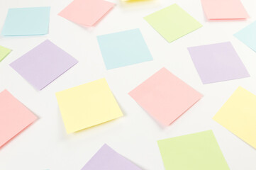 Top view of colorful sticky notes on white background. School, office wallpaper. Flat lay, copy space.