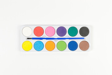 Top view of watercolor and paint brush on white background. Painting, art, copy space, flat lay.