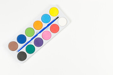 Top view of watercolor and paint brush on white background. Painting, art, copy space, flat lay.