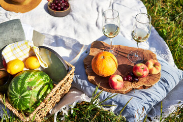 picnic in nature with fruit and wine on the river bank on a summer day 