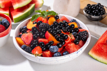 Summer fruit berry salad with tapioca pearls. Healthy diet refreshment salad with watermelon, strawberry, blueberry and bubble tea balls, on white table background copy space