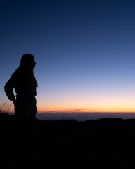 Girl silhouette in the mountain celebrating the climb in Spain