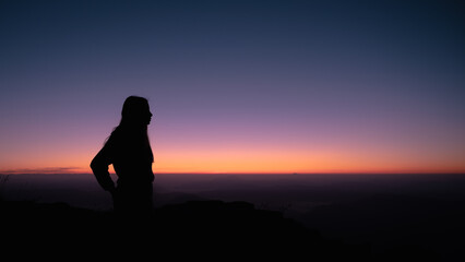 Girl silhouette in the mountain celebrating the climb in Spain