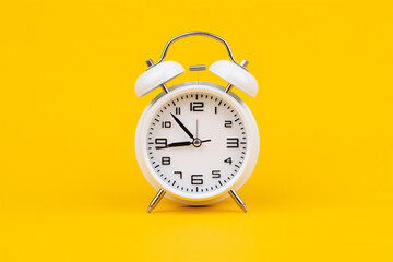 Alarm clock. Stationary photo in studio on yellow background, time concept.