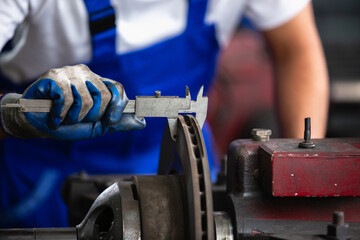 Engineering worker man wearing uniform safety working using vernier calipers measuring dimensions...