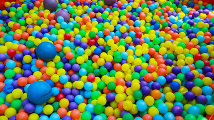 A vibrant and cheerful ball pit filled with an abundance of colorful plastic balls. A Colorful Sea of Plastic Balls in a Ball Pit