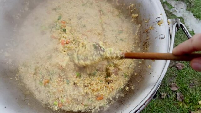 Ukrainian "Kulish" millet porridge with Salo mixing in kazan while Preparation traditional pottage cultural meal masterpiece popularized by Zaporizhian Cossacks, Ukraine.