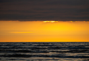 Obraz premium A beautiful sunrise over the Baltic sea - horizon and colorful sky. Natural summer scenery at the Baltic beach in Latvia, Northern Europe.