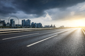 Fototapeta premium Asphalt highway road and modern city buildings scenery on cloudy day. car background.