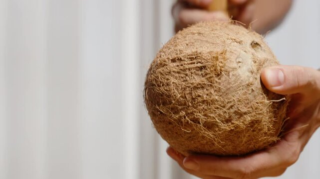 Man Hitting Hard Coconut Shell with a Wooden Stick Trying to Crack It Open. Slow Motion.