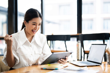 Happy young woman  looking at tablet excited by good news online, lucky successful winner woman...