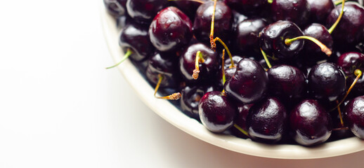 A bowl of cherries is shown on a white background