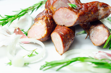 A pile of sausages with rosemary on top