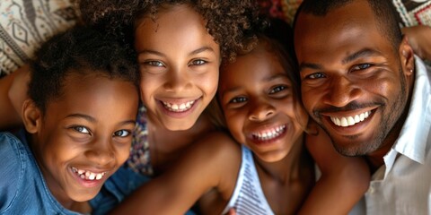 Fototapeta premium A family of four, two boys and two girls, are smiling and hugging each other