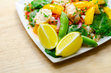 A plate of food with a yellow lemon and green peas
