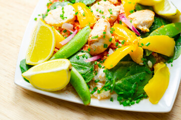 A plate of food with a yellow lemon and green peas