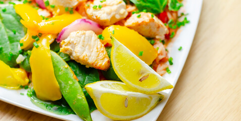 A plate of food with a yellow lemon and green peas