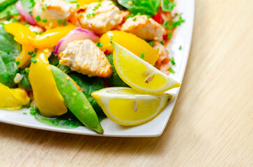 A plate of food with a yellow lemon and green peas